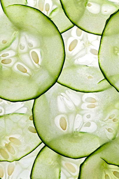 Thinly sliced cucumbers with bright light in the background