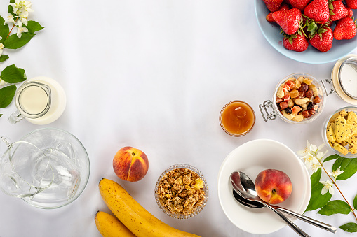 Healthy breakfast. Ingredients Granola, fruit, nuts, milk. Healthy food. granola breakfast ingredients on a white tablecloth. copy space for text