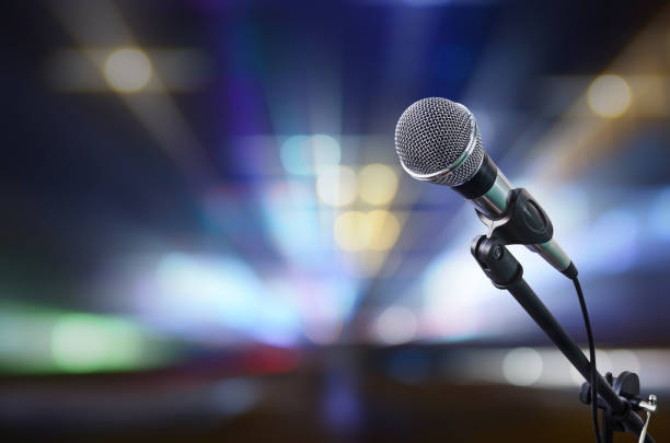 istock Close-Up Of Microphone Against Illuminated Lighting Equipment 1158988467