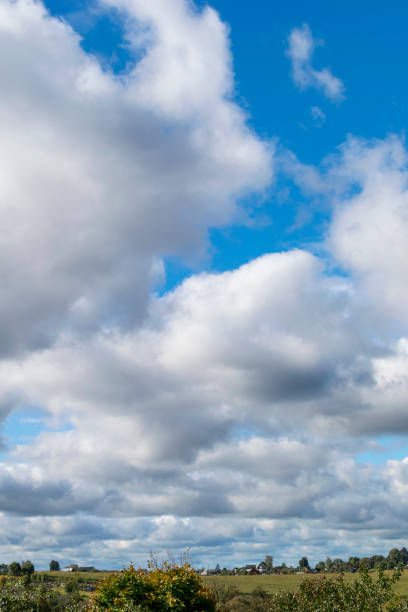 beautiful countryside landscape. cumulus humilis clouds in the sky at sunny day above the village - cumulus humilis imagens e fotografias de stock