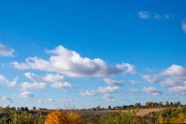 beautiful countryside landscape. cumulus humilis clouds in the sky at sunny day above the village - cumulus humilis imagens e fotografias de stock