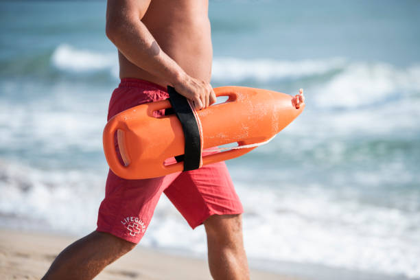 istock Unrecognizable Lifeguard with red float running on the beach. 1158996415