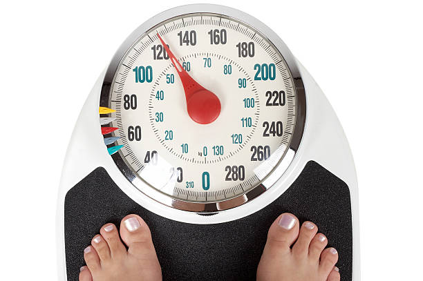 A Woman Weighing Herself On Bathroom Scales Stock Photo - Download Image  Now - Weight Scale, Scale, Human Foot - iStock