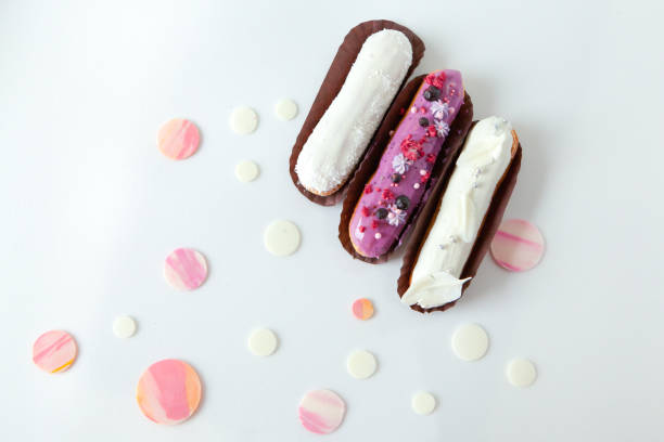 istock A set of three eclairs with different fillings and design isolate on a white surface decorated with drops of white chocolate 1159004918