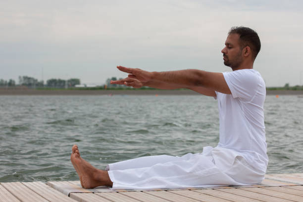 istock Man practice yoga on the beach at sunset 1159005462