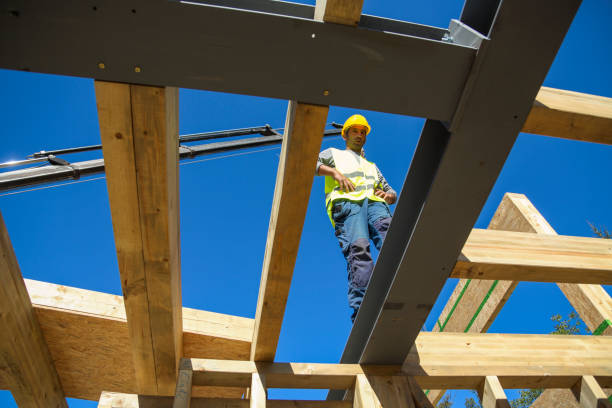 istock Construction worker standing on a wooden house construction site 1159006409