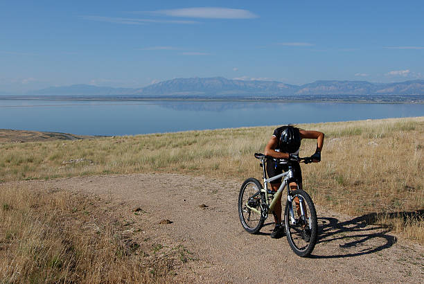 Female athletic cyclist taking a break on top of a hill stock photo