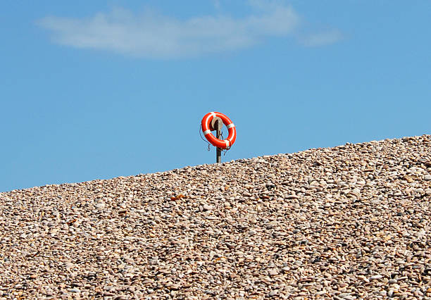 A red life belt on a pebble beach in Devon