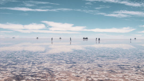 People silhouette and reflections in the Salar de Uyuni, Bolivia People silhouette and reflections on the mirror of sky in the Salar de uyuni salt lake in Bolivia salt flat stock pictures, royalty-free photos & images