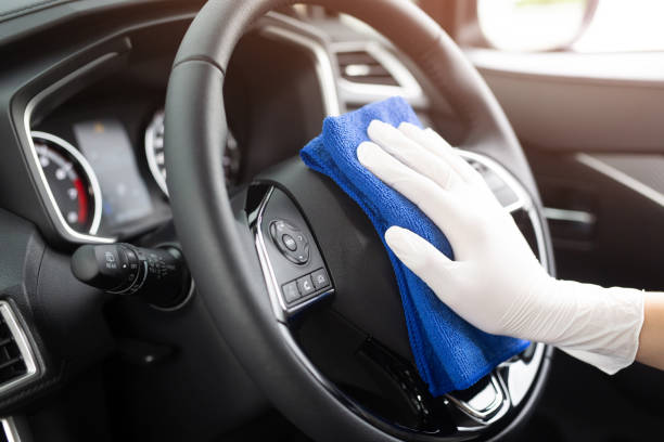 trabajador hombre usar guantes de limpieza de la consola interior del coche con paño de microfibra, detalles, concepto de servicio de lavado de coches. espacio de copia. - interior del coche fotografías e imágenes de stock