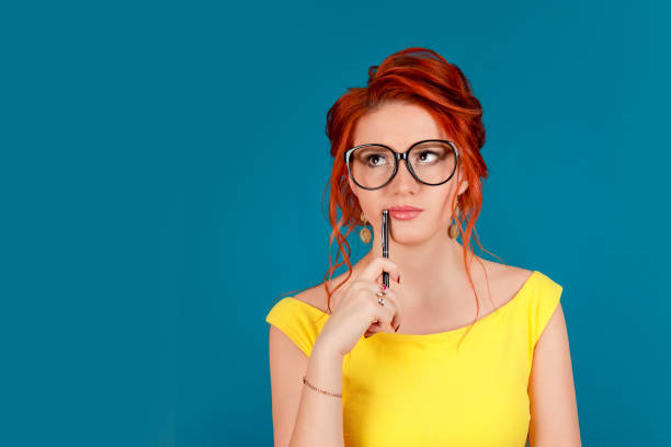 istock Attractive thoughtful businesswoman with a pen looking up 1159014530