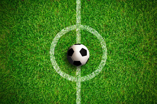 Overhead view on isolated soccer ball in field Overhead view on isolated soccer ball in field with white markings on grass. Dark vignette at edges. stadium playing field grass fifa world cup stock pictures, royalty-free photos & images
