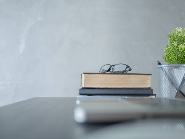 istock Glasses, books on black desk in the office with copyspace 1159015755