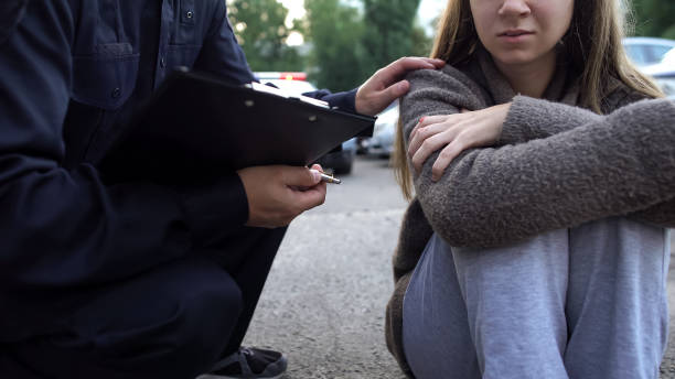 officer trying to calm down female victim of car accident, shocked girl crying - crime scene investigation imagens e fotografias de stock