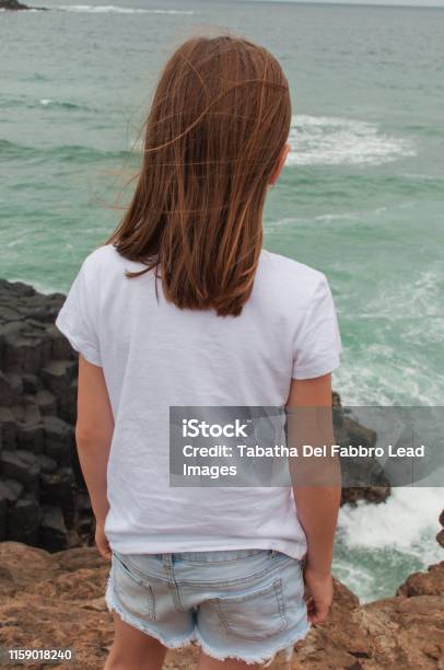 Girl Overlooking Cliff To The Ocean Alone Stock Photo - Download Image Now - Active Lifestyle, Adventure, Beach