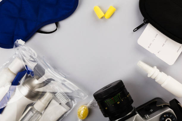istock Set for flight small bottles with cosmetics, sleep mask, camera, earplugs, nasal spray, air ticket and documents on gray background. Top view, copy space 1159019212
