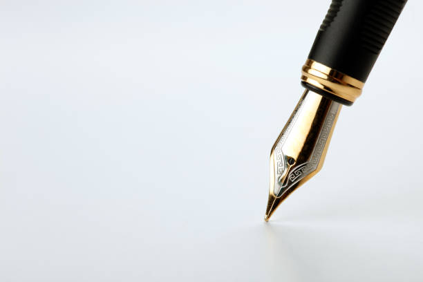 istock golden fountain pen writes on a white background closeup 1159021401