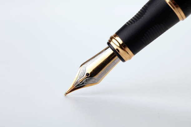istock golden fountain pen writes on a white background closeup 1159021407