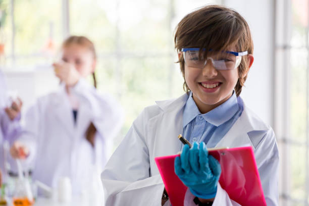 istock Pupils boy in white gown doing a chemical experiment write on clipboard in laboratory at school  . kids in science lab study . multi ethnic . caucasian , biochemistry . 1159024776