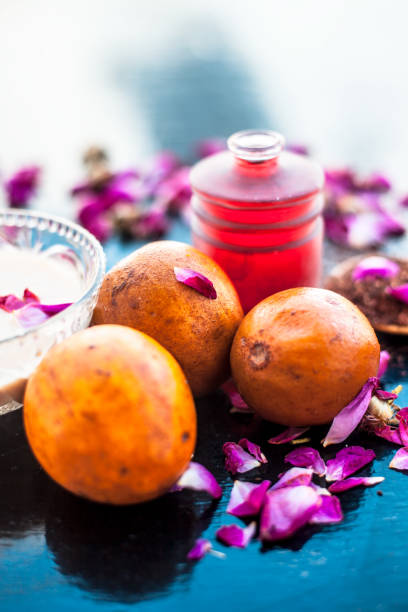 istock Face pack for cheeks on wooden surface consisting of sapodilla or chikoo well mixed with sandalwood using rose water in it. 1159024863
