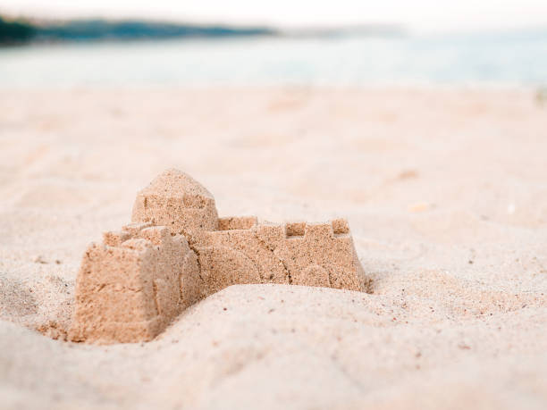 istock Sand castle decorated with blue red marine star fish 1159025796