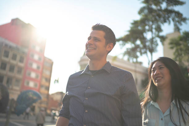 istock Diverse smiling couple walking on the street 1159025907