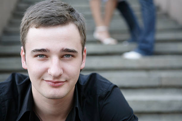 istock young handsome guy sitting on stairs 115902610