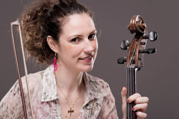 istock Beautiful dark haired female cellist with her instrument 1159027807