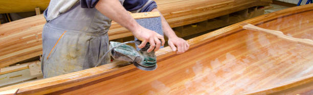 istock Young carpenter assembling new wooden canoe 1159027985