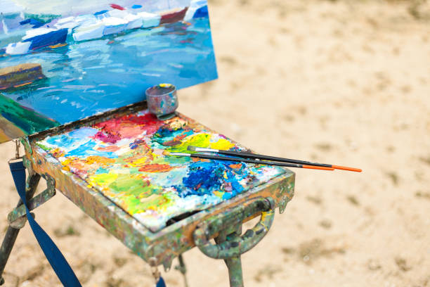 Colorido lugar de trabajo del artista con pinceles y pinturas al óleo al aire libre - foto de stock