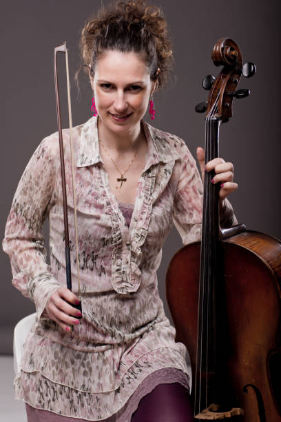 istock Beautiful dark haired female cellist with her instrument 1159029547