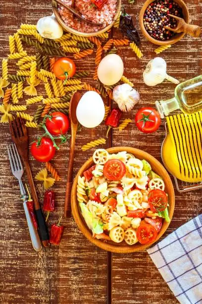 Pasta salad with cheese. Summer salad. Diet Diet. Pasta with vegetables on wooden table.