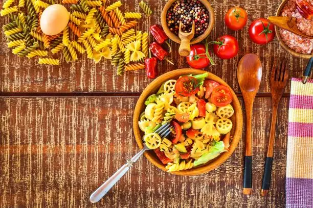 Pasta salad with cheese. Summer salad. Diet Diet. Pasta with vegetables on wooden table.