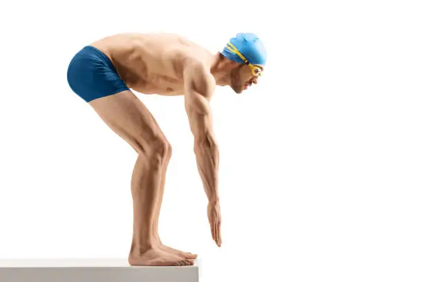 Full length shot of a male swimmer getting ready to start swimming isolated on white background