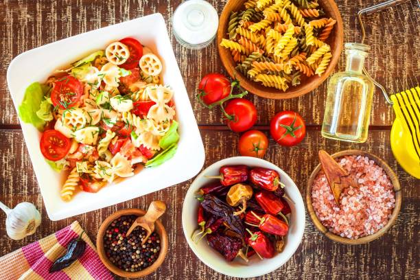 istock Pasta salad with cheese. Summer salad. Diet Diet. Pasta with vegetables on wooden table. 1159031832