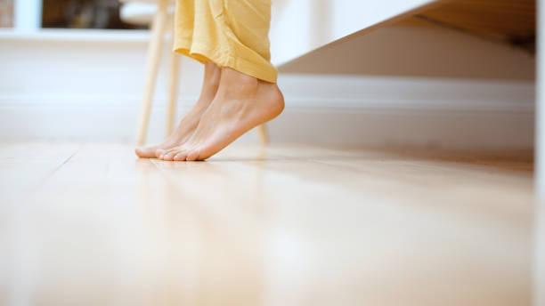 Close up of female feet getting out of bed in the morning. stock photo