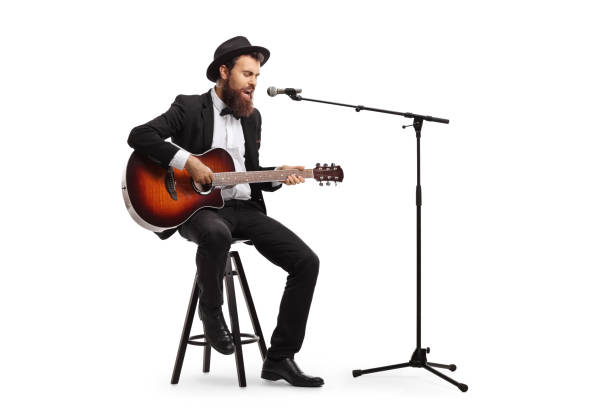 istock Musician singing on a microphone and playing an acoustic guitar 1159031941