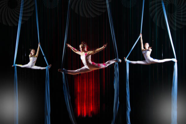 zirkusschauspielerin akrobaten performance auf leinwänden. team-mädchen führen akrobatische elemente in der luft. - airshow stock-fotos und bilder
