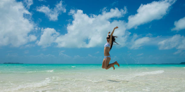 istock Woman jumping on the beach 1159033299