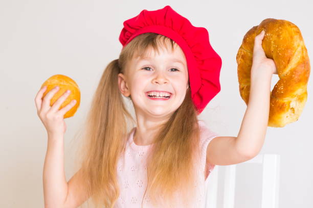 istock little girl face, red hat, baking bread, close up 1159033385