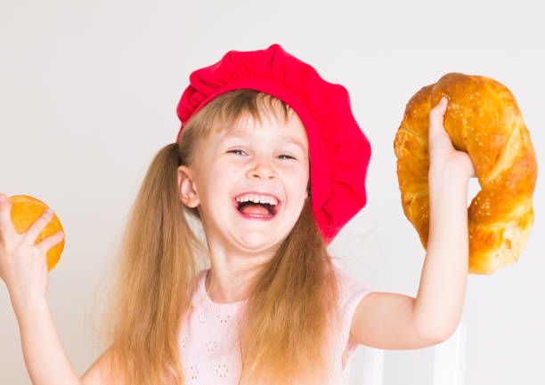 istock little girl face, red hat, baking bread, close up 1159033421
