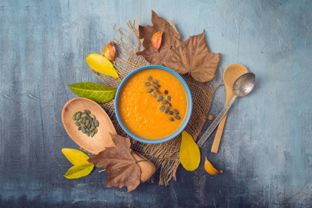 istock Pumpkin soup on rustic background. Autumn concept with fall leaves. Top view from above 1159034031