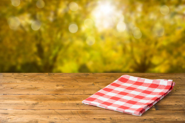 istock Empty wooden table with tablecloth over autumn nature park background 1159034110