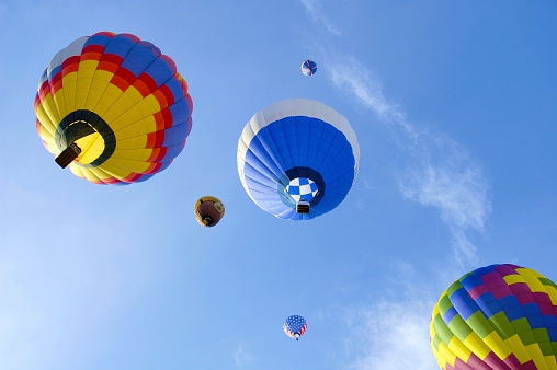 A group of bright colorful balloons soar in the air.