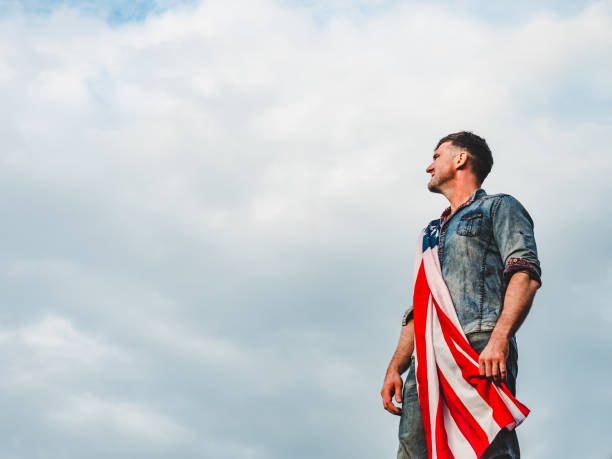 istock Handsome, young man holding an American flag 1159035431