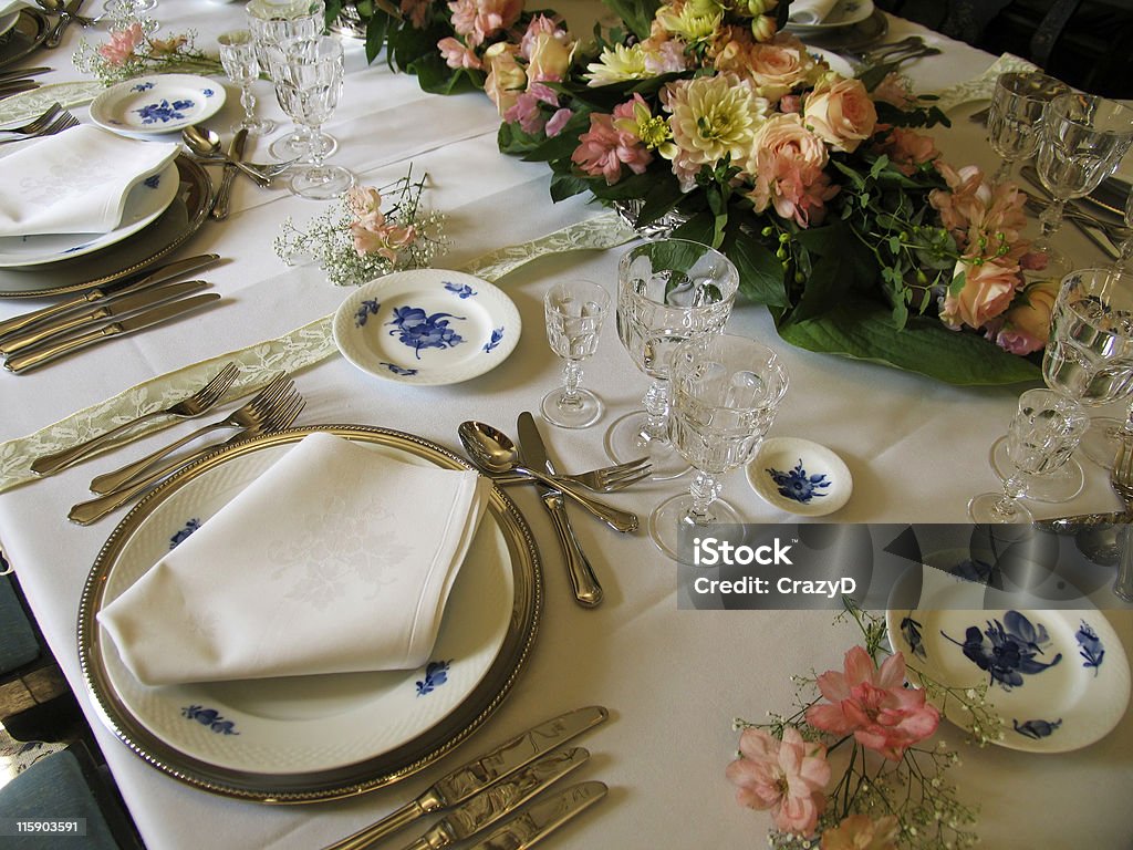 A retro table setting design for a dinner party A beautiful laid dinnertable in retro style with very old silver, glasses and porcelain. Natural lightening. Ancient Stock Photo