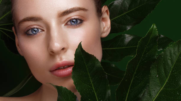 istock girl with green leaves. 1159036310