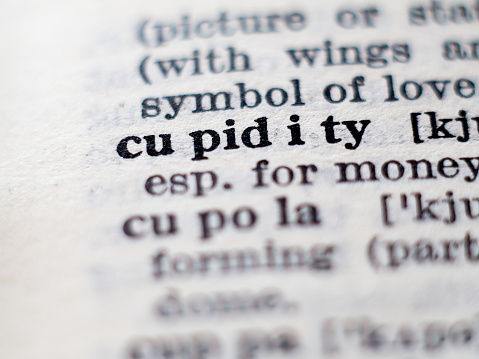 Dictionary definition of word cupidity. Selective focus.