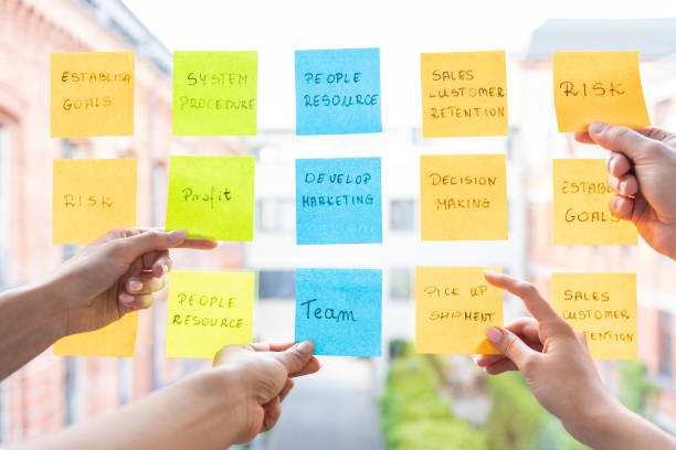 Young creative business people meeting at office. Business people meeting at office and use post it notes to share idea. Brainstorming concept. Sticky note on glass wall. office fun business adhesive note stock pictures, royalty-free photos & images