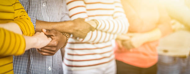 Unity and teamwork concept. Creative team meeting hands together in line. Young people in casual clothes are holding hands. Unity and teamwork concept. group of people standing together stock pictures, royalty-free photos & images